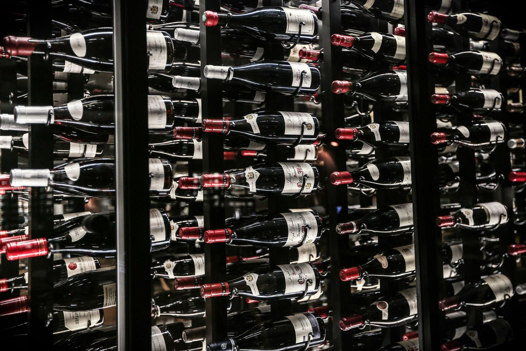 A modern, glass enclosed cellar filled with wine bottles