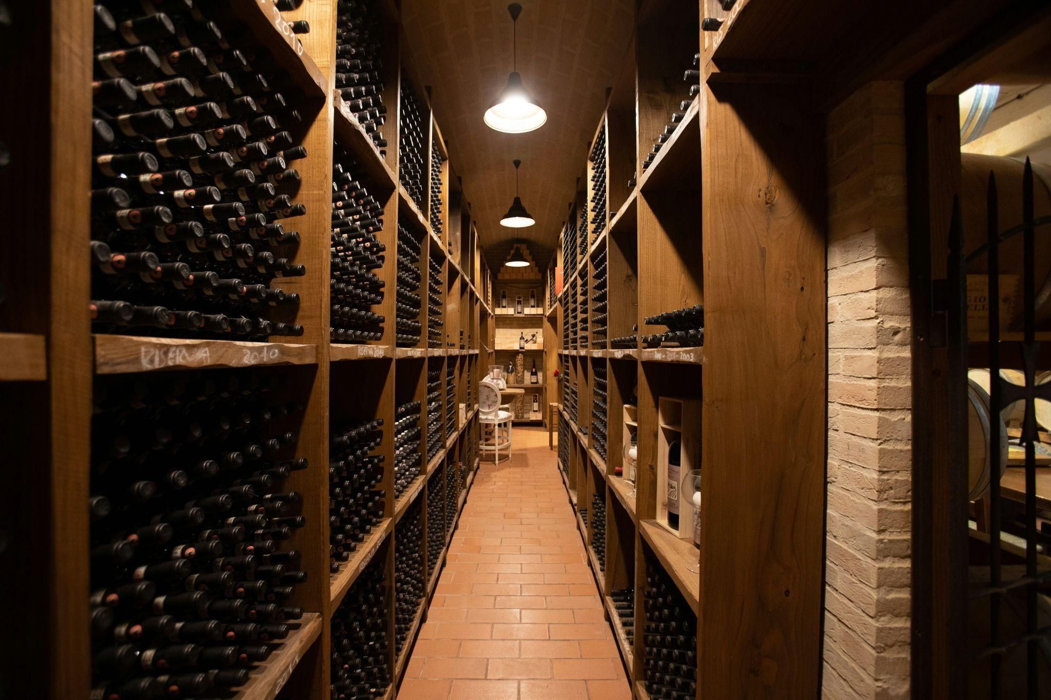 Four wine glasses containing different types of wine lined up on top of a wooden barrel