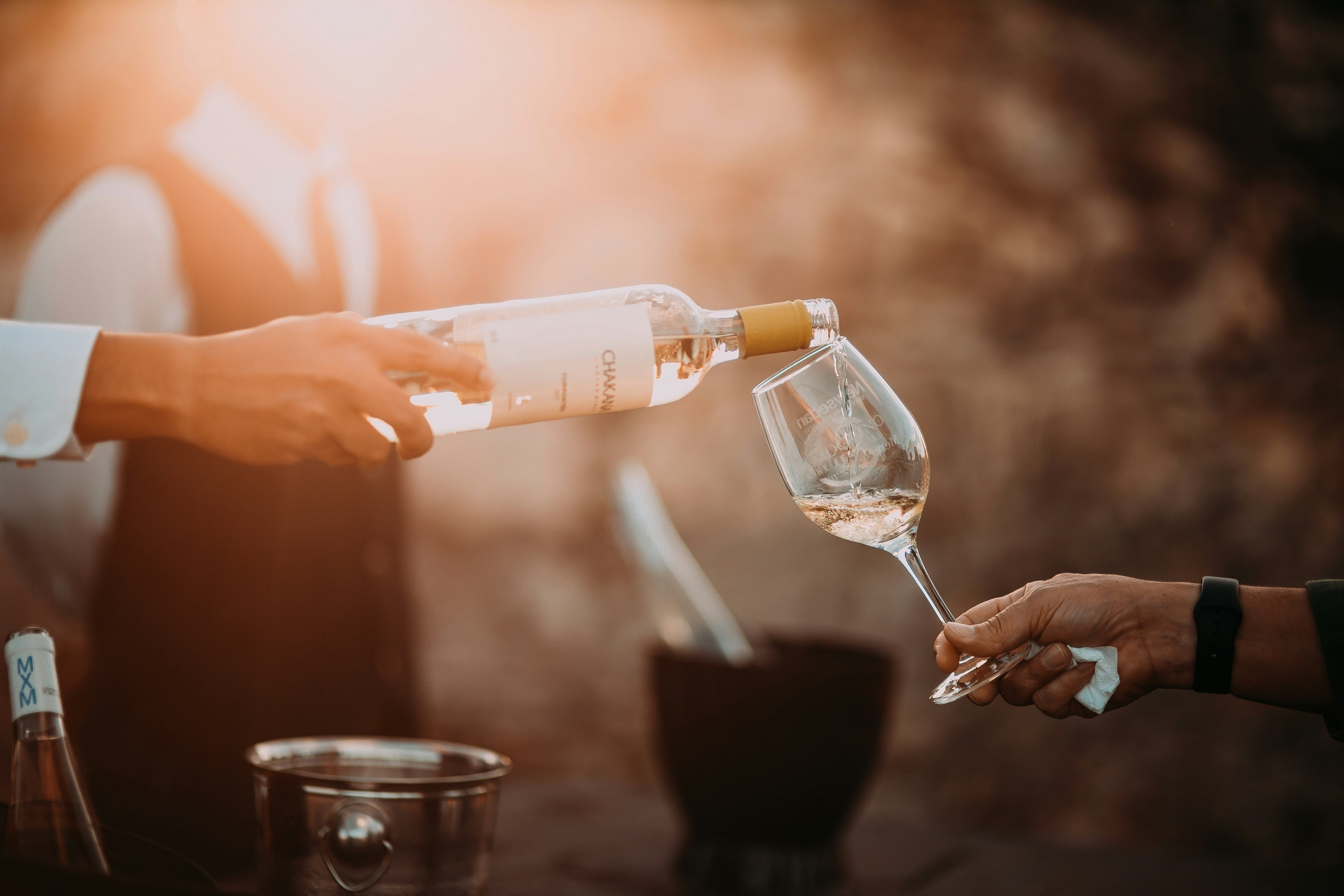 gentleman pouring rosé wine into a glass